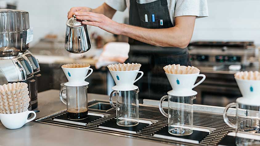 Barista bereitet Kaffee im Handfilter zu